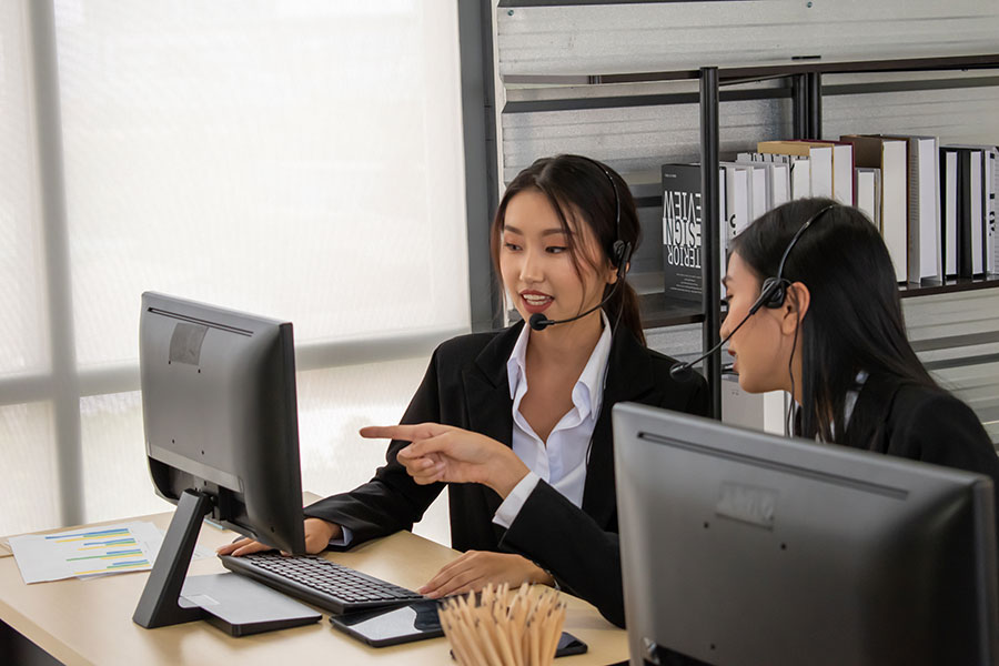 Two call agents reviewing screen
